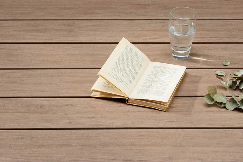 Un livre sur une terrasse en bois
